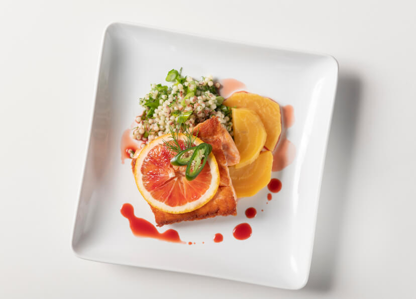 Plated salmon with couscous and blood orange.