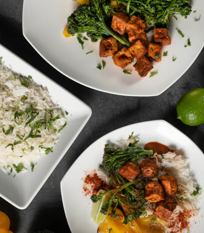 Three plated meals with marinated tofu, broccoli spears, and cilantro jasmine rice.